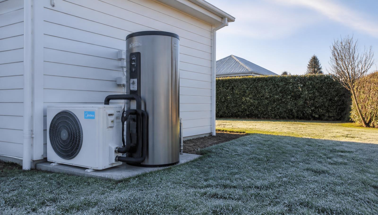 Heat pump hot water cylinder and outdoor unit installed beside a Christchurch home on a frosty Canterbury morning